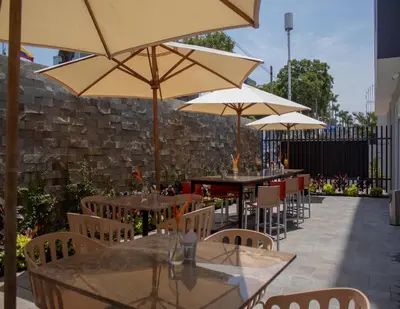 a patio with tables and chairs with umbrellas at Xima Lima San Isidro in Lima