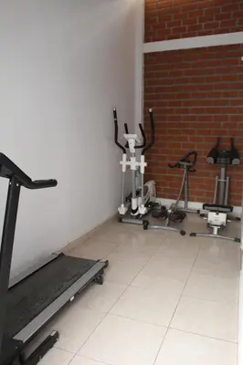 a room with several exercise bikes and a brick wall at Huacachina Desert House in Ica