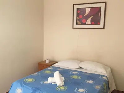 a bedroom with a bed with two towels on it at Paracas Backpackers House in Paracas
