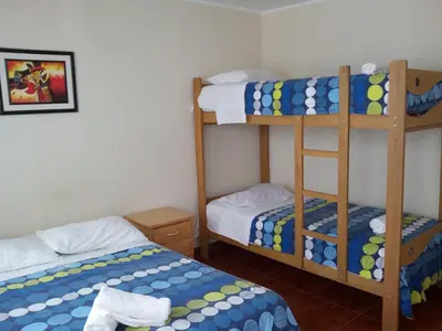 a room with two bunk beds and a bed at Paracas Backpackers House in Paracas