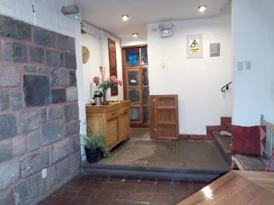 a room with a stone wall and a brick wall at Maison Fortaleza in Cusco