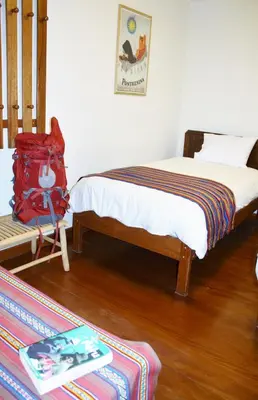 a bedroom with a bed with a red backpack on it at Maison Fortaleza in Cusco