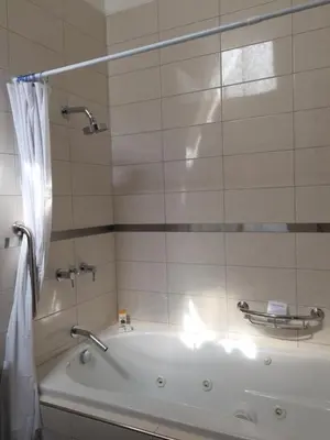 a bathroom with a bath tub with a shower at Zen Home & Garden House in Cieneguilla