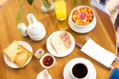 a table with breakfast foods and coffee and a bowl of fruit at Auka Boutique San Blas in Cusco
