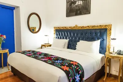 a bedroom with a large bed with a blue headboard at Auka Boutique San Blas in Cusco