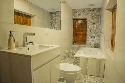 a white bathroom with a sink and a toilet at Auka Boutique San Blas in Cusco