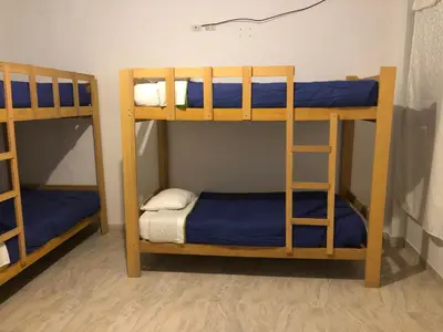 two bunk beds in a room with blue sheets at BUGANVILIA in Paracas