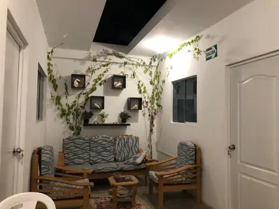 a living room with two chairs and a table at BUGANVILIA in Paracas