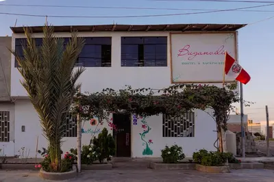 a building with a flag and flowers in front of it at BUGANVILIA in Paracas