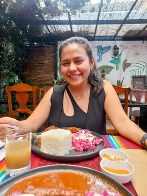 a woman sitting at a table with a plate of food at Samanai Wasi in Lima