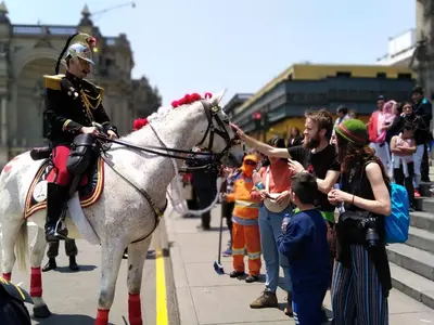 a man in uniform on a white horse on a street at Samanai Wasi in Lima