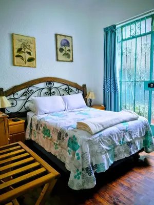 a bedroom with a bed and a large window at La Casona Azul in Lima