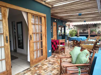 a patio with wooden doors and chairs and a table at La Casona Azul in Lima