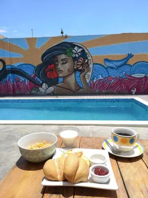 a table with a plate of food and a painting at Surfari Punta Rocas in Punta Negra