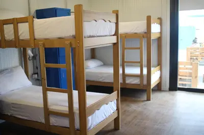 three bunk beds in a room with a window at Surfari Punta Rocas in Punta Negra