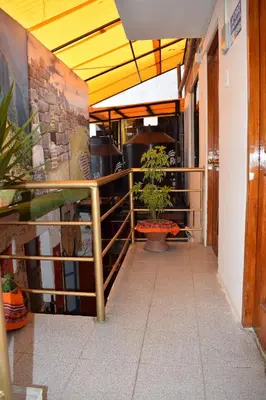 a corridor of a restaurant with two potted plants at Hostal Casa Del Inka in Cusco