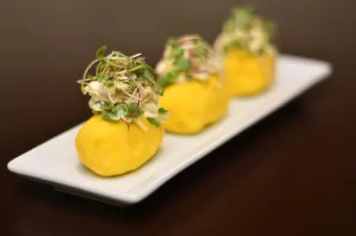 a white plate with four yellow food on it at Dazzler by Wyndham Lima San Isidro in Lima