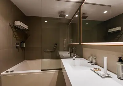 a bathroom with two sinks and a tub and a mirror at Dazzler by Wyndham Lima San Isidro in Lima