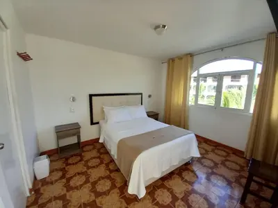 a bedroom with a large bed and a window at Hostal Los Frayles in Paracas