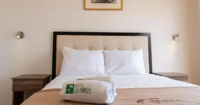 a bed with a pile of towels on top of it at Hostal Los Frayles in Paracas