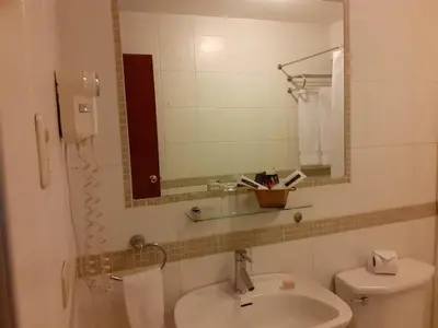 a bathroom with a sink and a toilet and a mirror at Hotel Melodia in Lima