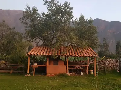 a gazebo with a tree on top of a field at Mágico lugar en el Valle Sagrado in Cusco
