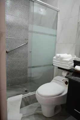 a bathroom with a toilet and a glass shower at Altipacha Ayacucho Hotel in Ayacucho