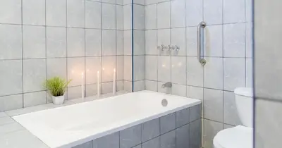 a bathroom with a bath tub and a toilet at Hotel Residencial Los Frayles in Paracas