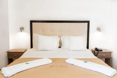 a hotel room with a bed with two white pillows at Hotel Residencial Los Frayles in Paracas