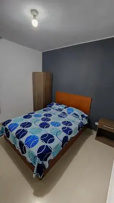 a bedroom with a bed with a blue at Hospedaje Villa Del Sol in Ica