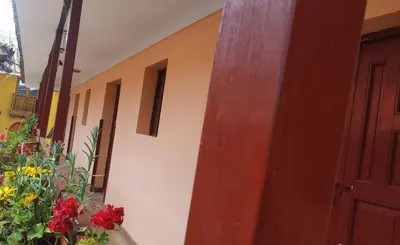 a room with a door and flowers next to a building at Casa Anais y Nicolas económico in Cusco