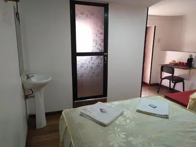 a room with a bed and a sink and a window at Casa Anais y Nicolas económico in Cusco