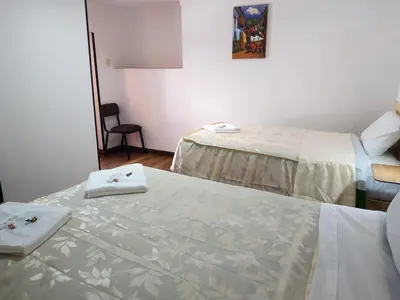a room with two beds with towels on them at Casa Anais y Nicolas económico in Cusco