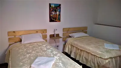 two beds in a small room withermottermottermott at Casa Anais y Nicolas económico in Cusco