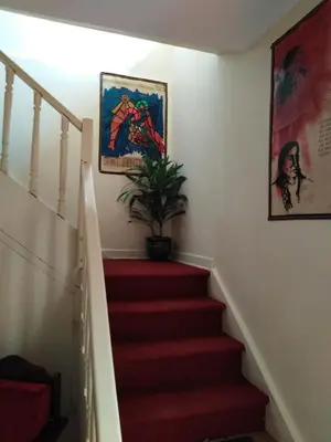 a staircase with a potted plant and a painting at Secret Garden in Cusco
