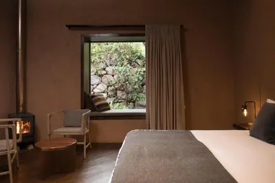 a bedroom with a bed and a window and a chair at Andenia Boutique Hotel, Sacred Valley in Urubamba