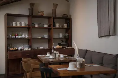 a dining room with two tables and a shelf at Andenia Boutique Hotel, Sacred Valley in Urubamba