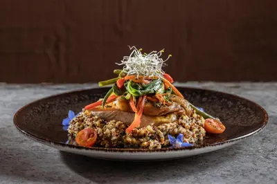 a plate of food withinoa and vegetables on a table at Casa del Sol Machupicchu in Machu Picchu