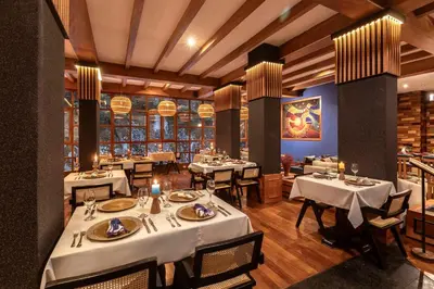 a restaurant with tables and chairs in a room at Casa del Sol Machupicchu in Machu Picchu