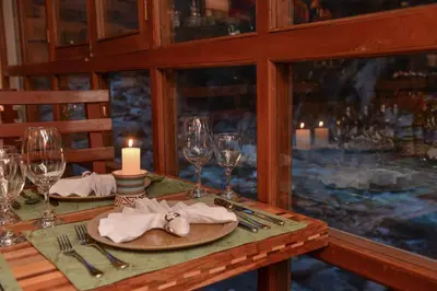 a table with a candle and wine glasses on it at Casa del Sol Machupicchu in Machu Picchu