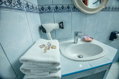 a bathroom with a sink and a pile of towels at MAPILAND- Hotel Boutique in Machu Picchu