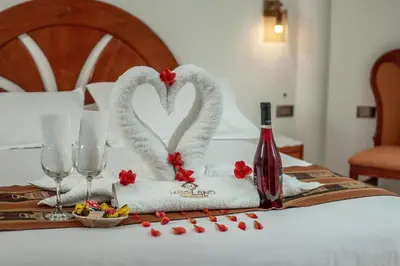 a table with two swans towels and a bottle of wine at MAPILAND- Hotel Boutique in Machu Picchu