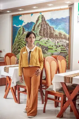 a woman is standing in a room with a painting at MAPILAND- Hotel Boutique in Machu Picchu