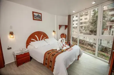 a bedroom with a bed and a large window at MAPILAND- Hotel Boutique in Machu Picchu