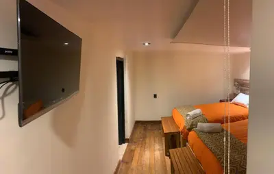 a bedroom with a bed and a flat screen tv at Gaia House Hostel in Cusco