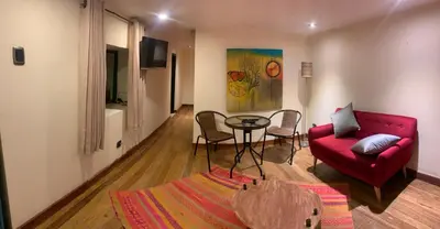 a living room with a red couch and a table at Gaia House Hostel in Cusco