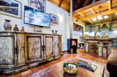 a living room with a large wooden cabinet and a fireplace at VILLA APU CHICON (Apu Wasi & Inti Wasi) in Urubamba