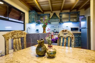 a kitchen with a table with chairs and a refrigerator at VILLA APU CHICON (Apu Wasi & Inti Wasi) in Urubamba