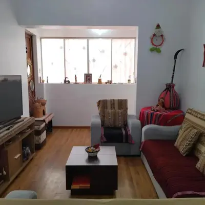 a living room with a couch and a tv at Piso de Kireyna in Cusco