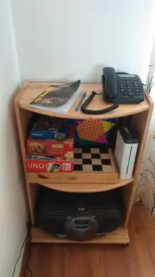 a book shelf filled with books and a telephone at Piso de Kireyna in Cusco